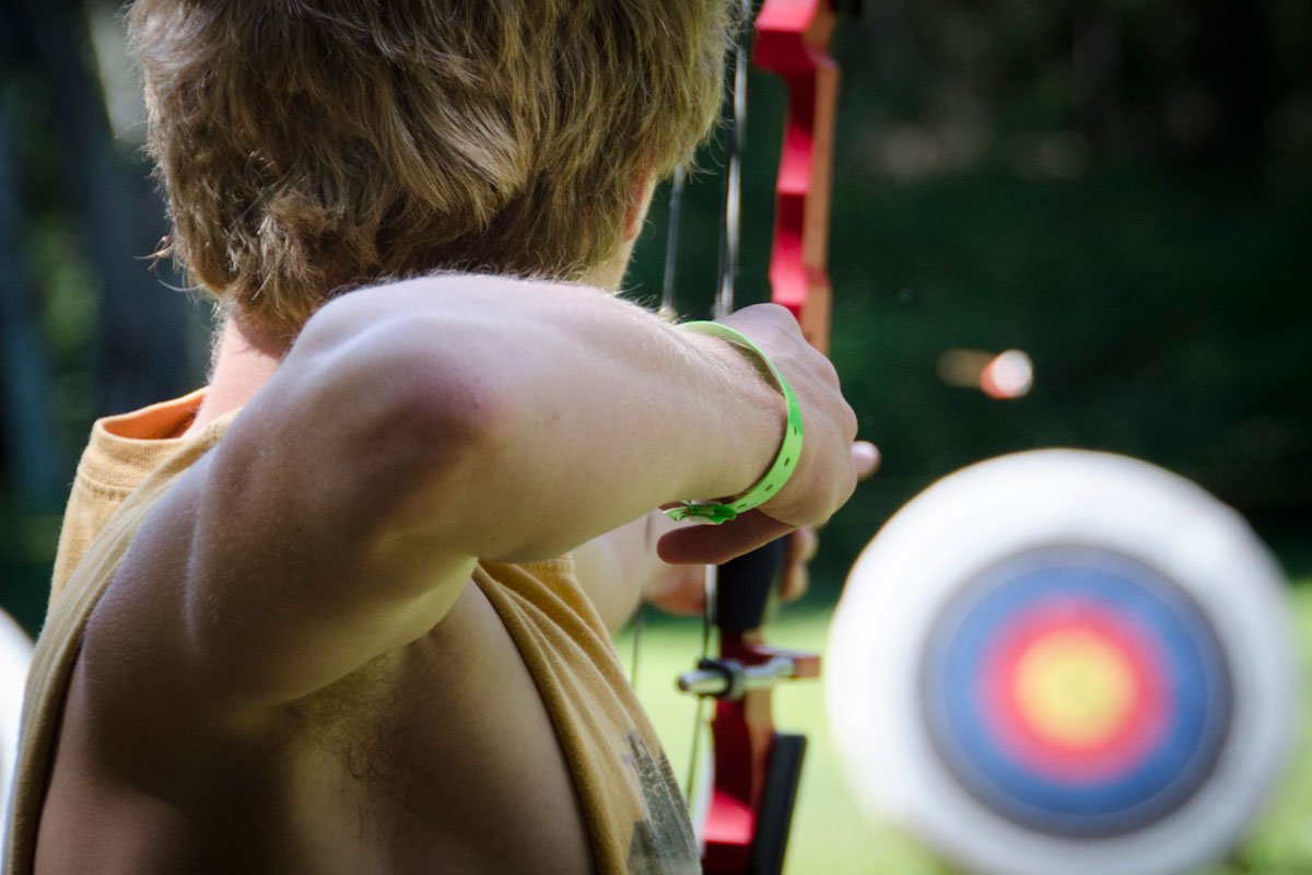 A closeup of a Scout with the bow drawn aiming downrange at a target