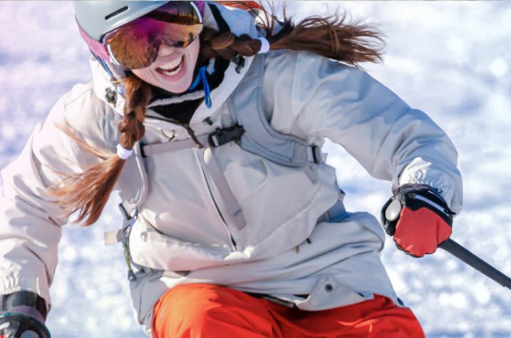 A closeup of a girl skiing downhill
