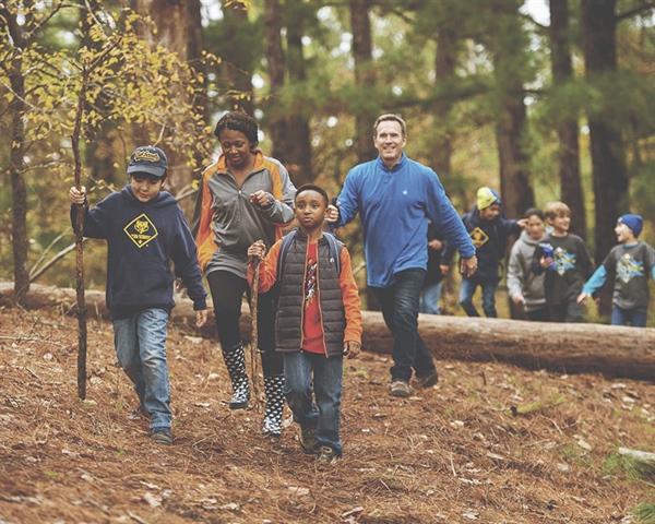 A group of youth and adults hiking down a trial