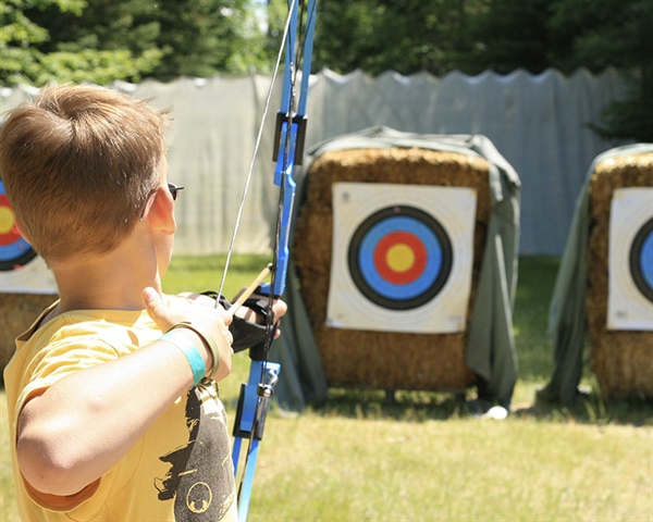 A young boy shooting a boy at an archery target