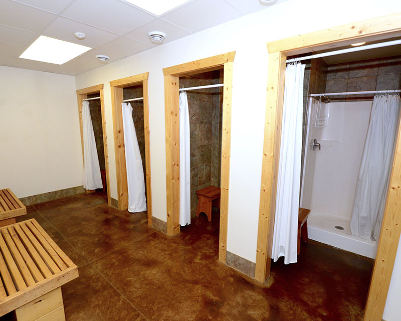 A room with four separate shower stalls, each with their own entry